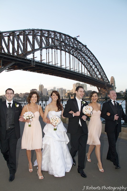 Bridal party walking arm in arm laughing - wedding photography sydney